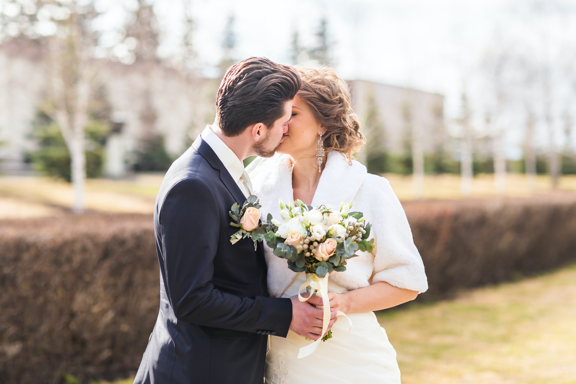 bride-and-groom-kissing-on-their-wedding-day-outdoors.jpg