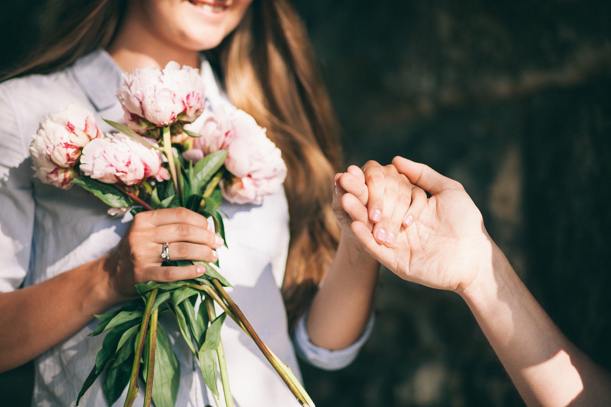 woman-with-engagement-ring-and-peony-bouquet.jpg